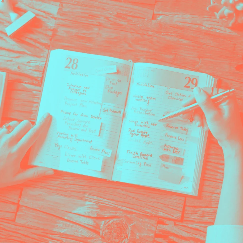 mani che compilano agenda editoriale a mano